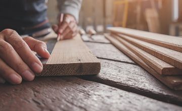 Carpenter working with equipment on wooden table in carpentry shop. woman works in a carpentry shop.