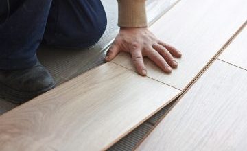 worker makes markup for laying laminate flooring